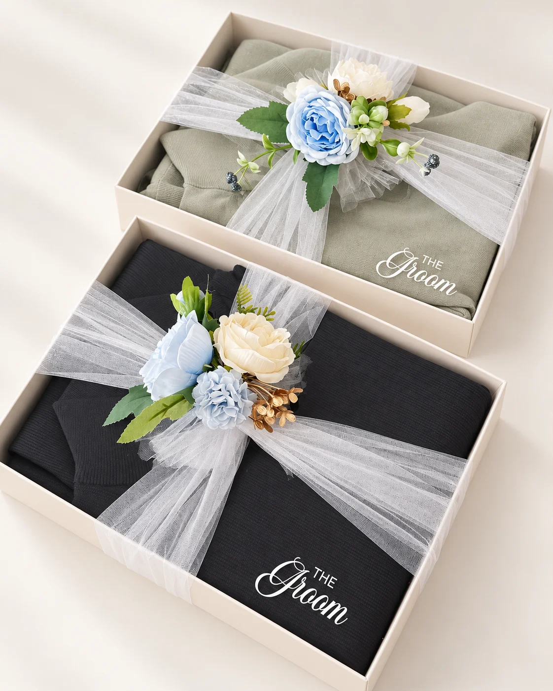Suit boxes styled with outfits, pale blue flowers and white vinyl lettering